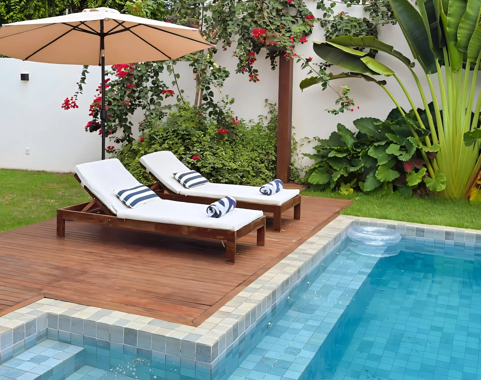 Piscina privativa com deck de madeira e espreguiçadeiras